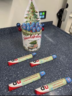 Ein selbst gebastelter Adventskalender für Rettungskräfte steht in einem Rettungswagen. Es handelt sich um eine Packung mit 24 Schokoriegeln. Auf jedem Schokoriegel befindet sind eine Banderole mit einem nummerierten Blaulicht und einer Du-Botschaft. 