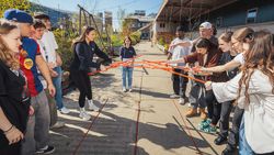 Mehrere junge Menschen spielen draußen gemeinsam ein Spiel.