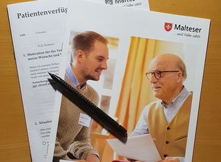 Malteser Patientenverfügung liegt mit einem Stift auf einem Tisch. 