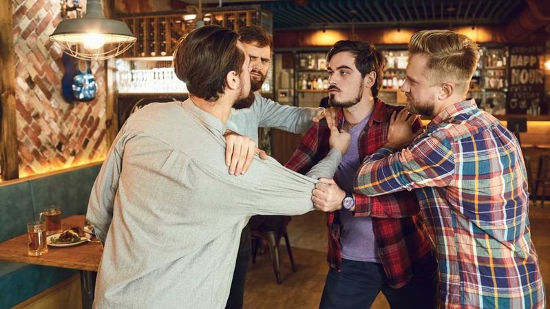 Junge Männer bei einer Rangelei in einer Bar.