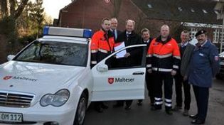 Mehrere Malteser Helfer stehen am Einsatzfahrzeug