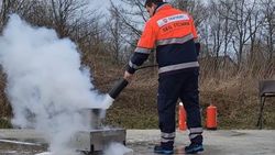 Ein Mann in Einsatzkleidung löscht ein kleines Feuer