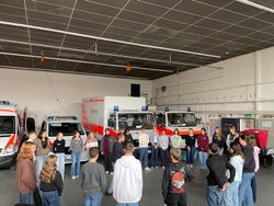 Auf dem Foto sind die Teilnehmenden der Ausbildung in der Fahrzeughalle der Mainzer Malteser zu sehen.