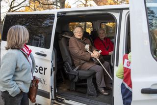 Ältere Personen steigen aus einem Malteser Fahrzeug aus