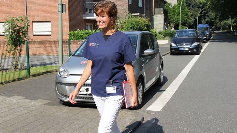 Mitarbeiterin der Malteser Ambulanten Dienste auf dem Weg zu Patienten.