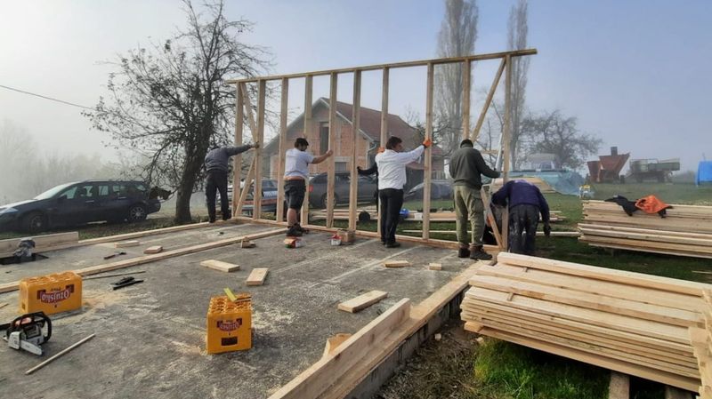 Fünf Männer, die am Rohbau eines Hauses arbeiten 