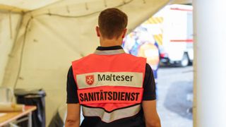 Sanitäter in Malteser Einsatzkleidung von hinten fotografiert