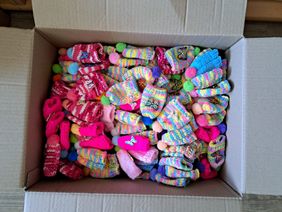 Eine Auswahl der insgesamt 2.300 Mützchen, die die Mutter einer ehrenamtlichen Malteser-Helferin für die Kampagne gestrickt hat.