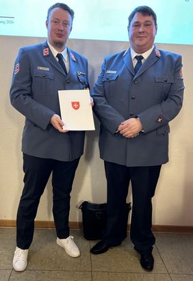 Andreas Töpfer und Matthias Lieske posieren in Malteser Dienstanzügen für das Foto