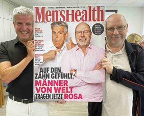 Raphael Ebenhoch und Andreas Zahn halten ein Bild im Stil eines Zeitschriftencovers hoch