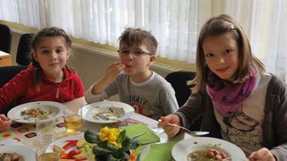 Kinder lachen fröhlich beim Mittagessen