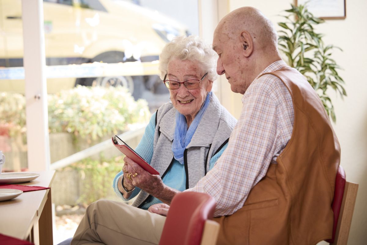 Eine ältere Frau zeigt einem älteren Mann etwas am Handy