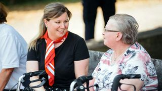 Eine Helferin der Malteser begleitet eine Dame bei einem Ausflug