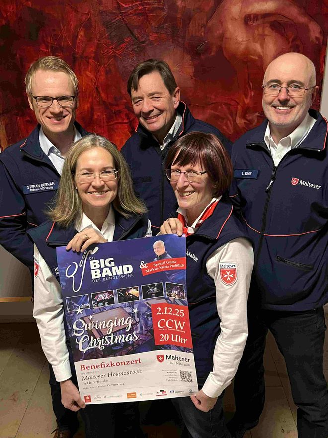 Maltesergruppe hält Plakat für Benefizkonzert