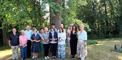 Frauen und Männer stehen im Park der Stille in einer Gruppe zusammen.