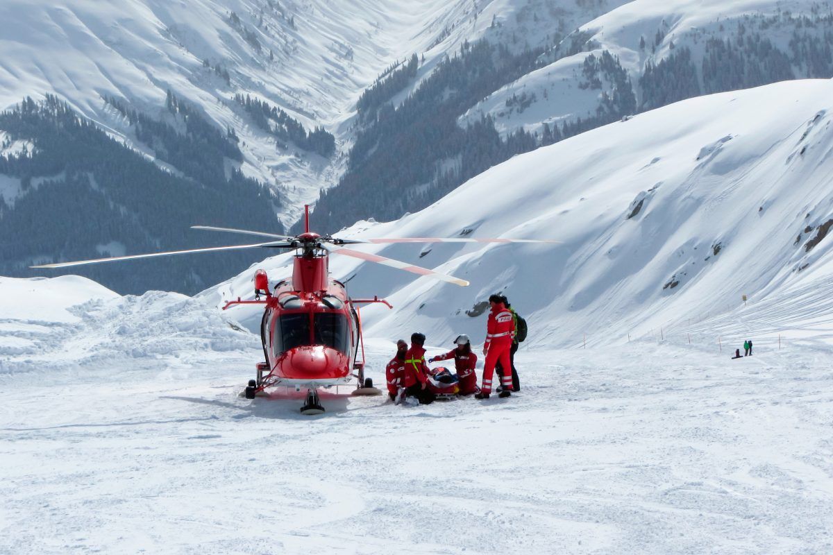 Helfende der Bergrettung mit einem Hubschrauber im Schnee
