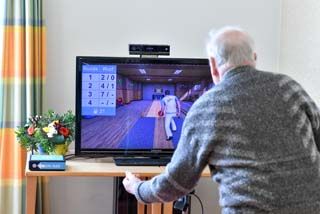 Bewohner spielt auf dem Fernseher Bowlen 