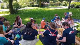 Eine Gruppe von Kindern und Jugendlichen macht ein Picknick.