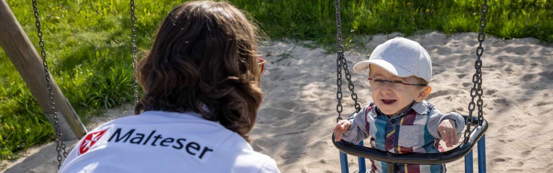 Eine Pflegefachkraft hält Luka auf dem Arm und unterstützt ihn bei der Beatmung.