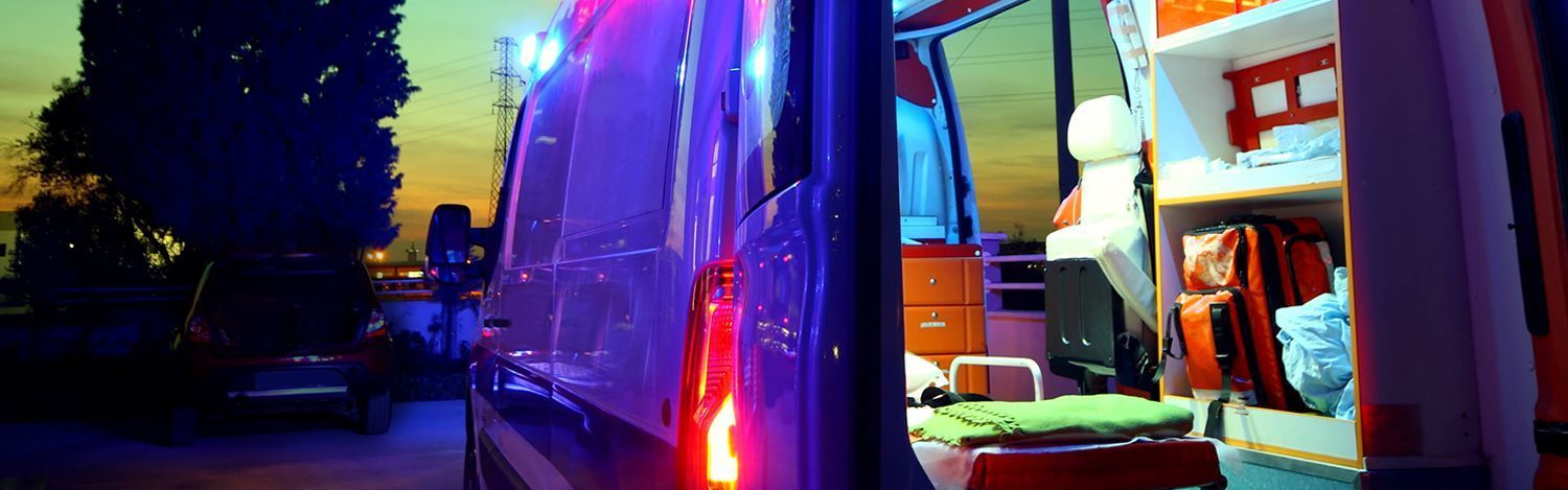 Ein Rettungswagen bei Nacht mit geöffneten Hecktüren.