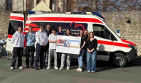 Gruppe Menschen vor Herzenswunsch-Krankenwagen