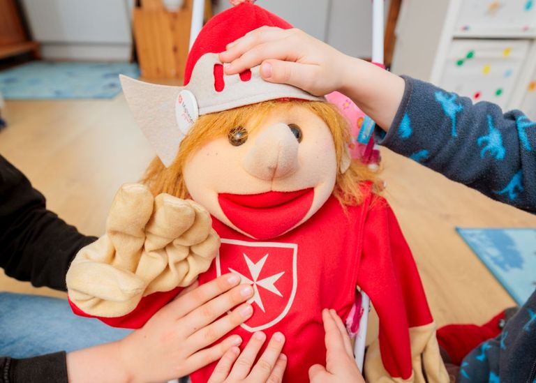 Eine Handpuppe in der Kleidung eines Malteserritters