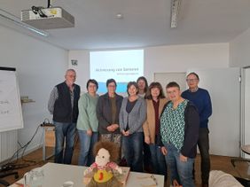 Gruppenfoto der acht neuen Ehrenamtlichen im Schulungsraum