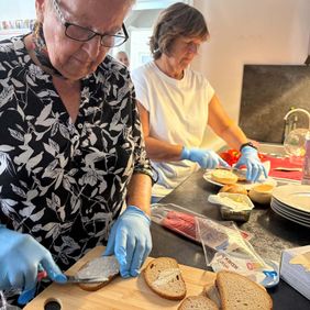 Zwei Frauen schmieren Brötchen für das Malteser-Café