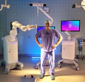 Arzt steht vor dem Wirbelsäulenroboter Medtronic Stealth AXiS™ in OP-Kleidung.