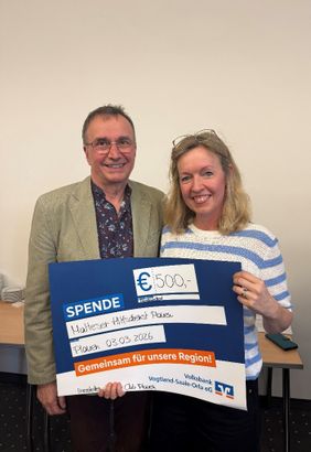 Zwei Personen stehen nebeneinander in einem Raum und halten gemeinsam einen großen Spendenscheck. Der Scheck zeigt eine Spendensumme von 500 Euro sowie die Angaben „Malteser Hilfsdienst Plauen“ und das Datum „03.03.2026“. Der Scheck trägt zudem den Schriftzug „Gemeinsam für unsere Region!“ und Logos der beteiligten Organisationen. Im Hintergrund sind ein Tisch und neutrale Raumelemente zu sehen.