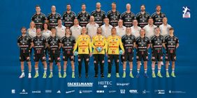 Teamfoto des Handballclubs HC Erlangen mit Spielern in schwarzen Trikots und Betreuern in weißen Shirts.