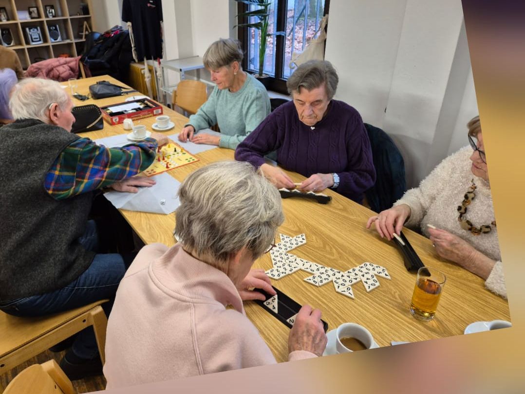 Seniorinnen und Senioren beim Spielen an einem Tisch