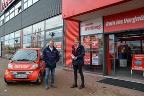 Zwei Mitarbeitende des Hausnotrufes stehen vor dem Media Markt.