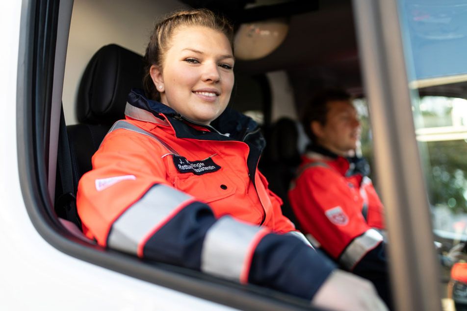 Es wird eine Malteser Notfallsanitäterin aus dem Rettungsdienstwagen gezeigt.