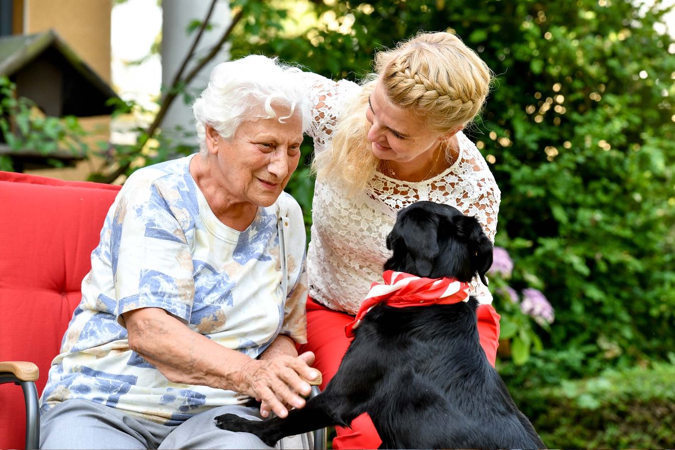 Begleiterin des sozialen Dienstes besucht Bewohnerin mit einem Hund 