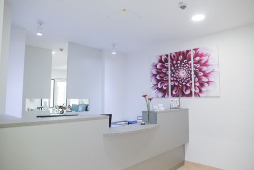 Empfangstresen mit zwei Arbeitsplätzen und dekorativem Wandbild im Hintergrund.