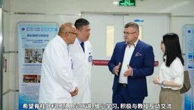 Vier Personen im Gespräch in einem Klinikflur, darunter zwei Ärzte, ein Mann im Anzug und eine Frau in Weiß.