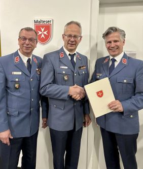 Gruppenbild Diözesanleiter Prof. Dr. Christopher Wolf (r.) und der stellvertretende Diözesanleiter Matthias Geist (l.) überreichen Bernhard Czekalla die Ernennungsurkunde. (Foto: Malteser Speyer)(Foto: Malteser Speyer)