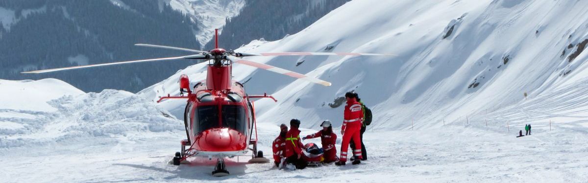 Helfende der Bergrettung mit einem Hubschrauber im Schnee