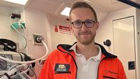 Ein Mann in rettungsdienstlicher Bekleidung im Inneren eines RTW blickt freundlich in die Kamea.