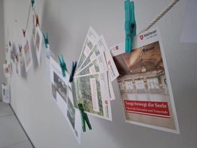 Das Bild zeigt Flyer der Traueranlaufstelle an einer Kordel aufgehängt