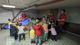 Mit ihren Betreuern spielen Kinder zum Schutz vor Bomben in einem Keller. Foto: Malteser Ukraine