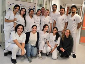 Gruppenfotos mit Pflegeauszubildenden und zwei Lehrkräften