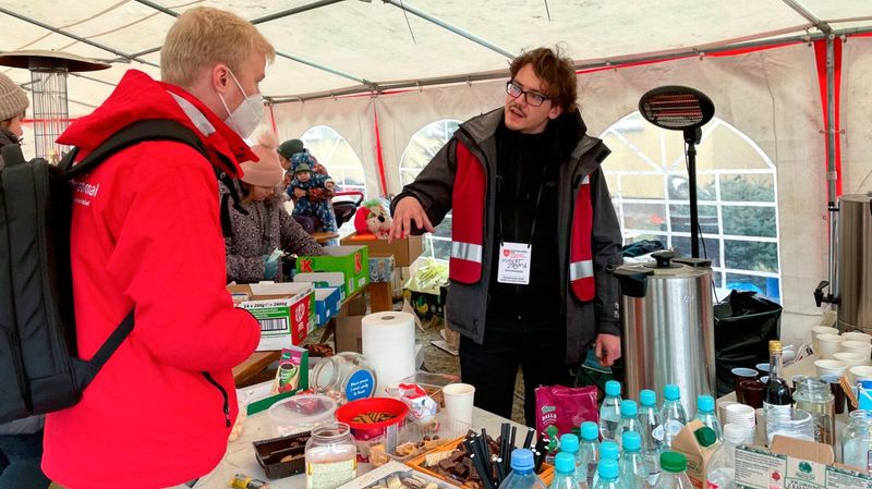 Zwei Männer in einem Zelt mit Hilfsgütern.