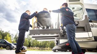 Zwei Mitarbeitende des Malteser Fahrdienstes helfen einer Person im Rollstuhl.