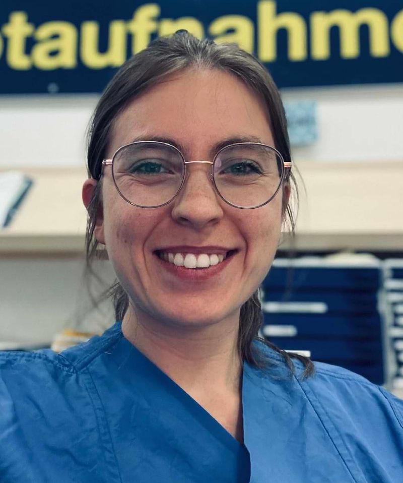 Selfie einer lächelnden jungen Frau mit Brille.