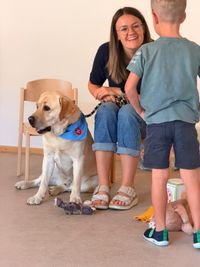 Der Malteser-Besuchshund Henry und seine Besitzerin sprechen mit einem Kindergartenkind.