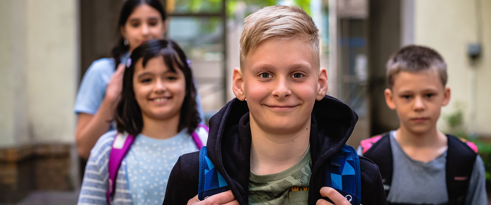 Fröhliche Kinder schauen in die Kamera.