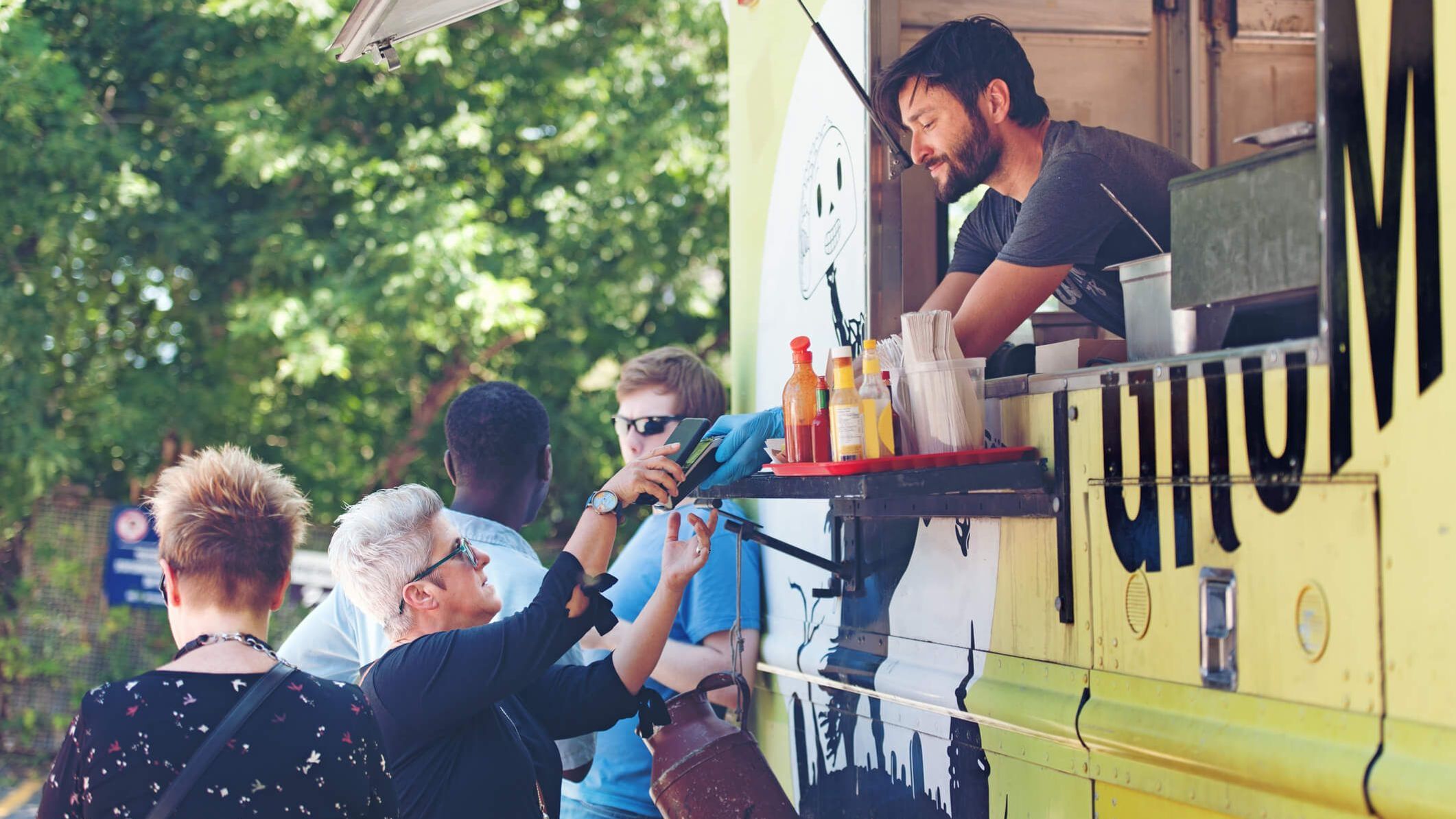 Mann bedient ältere Dame aus einem Foodtruck