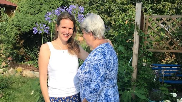 Eine junge Frau schaut in die Kamera, die ältere Frau ist weggedreht.